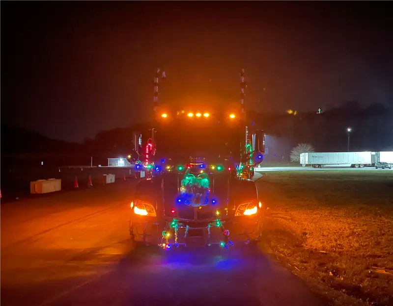 Truck adorned with colorful holiday lights at night