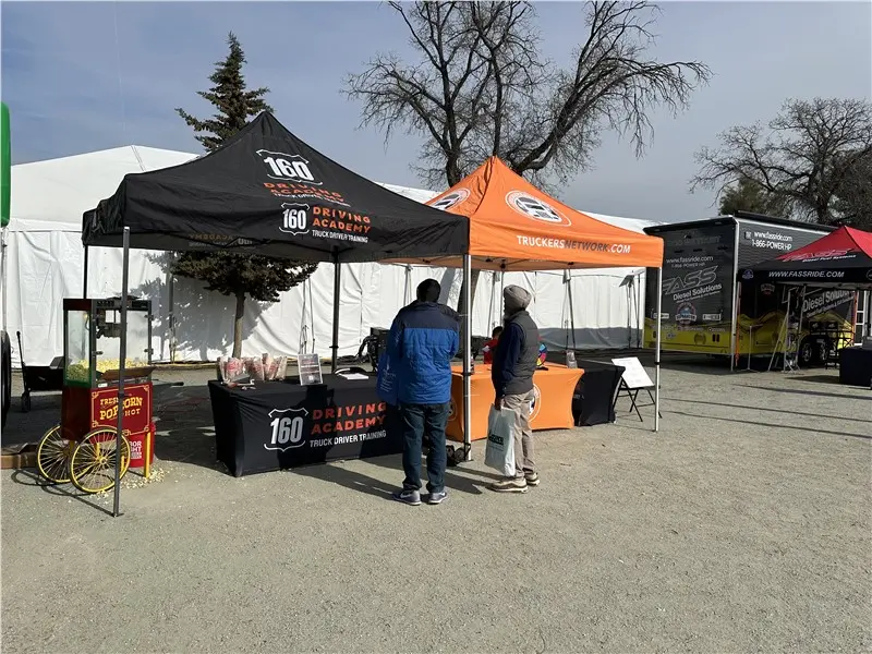 People visiting 160 Driving Academy expo booth