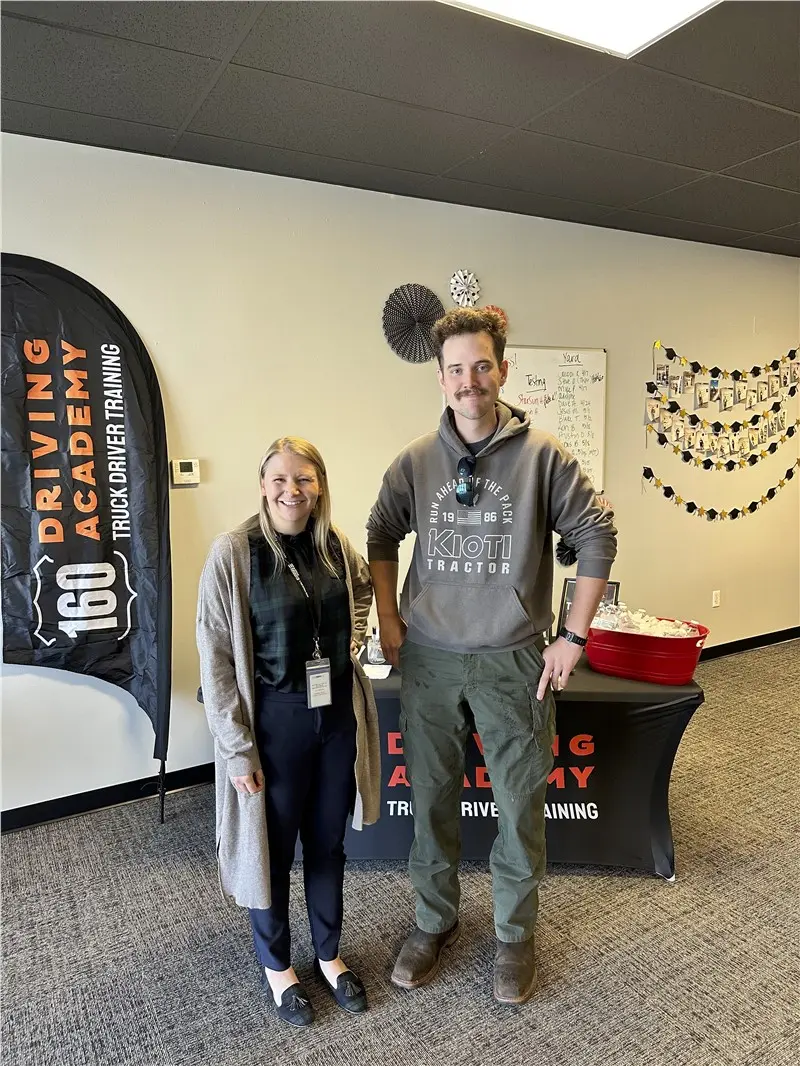 Two people smiling at 160 Driving Academy event