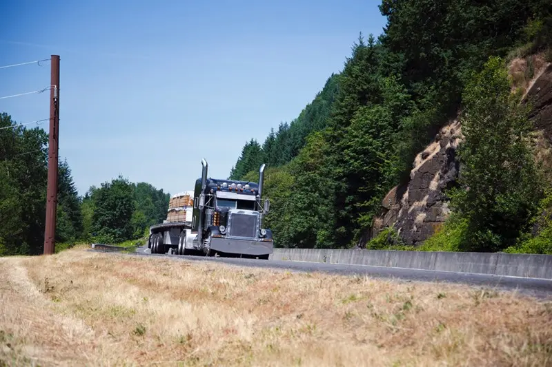 Black truck driving on a sunny highway