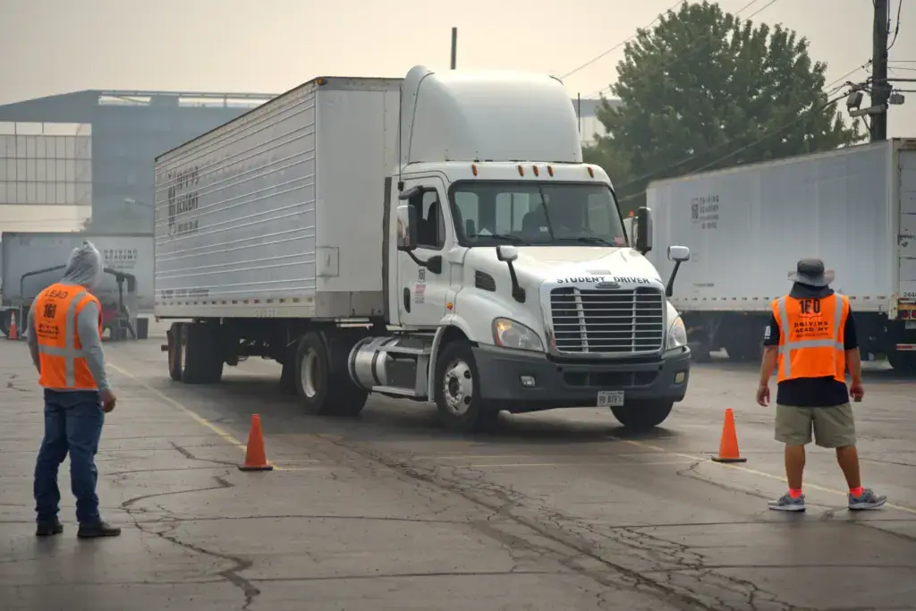 Truck practicing backing between cones with observers