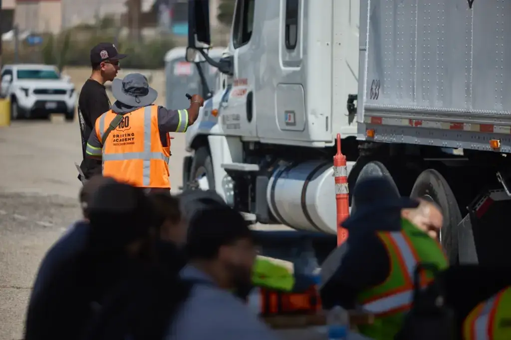 Instructor guiding students near a truck