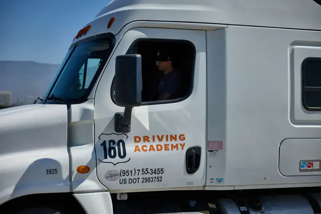 CDL student sitting in truck cab window
