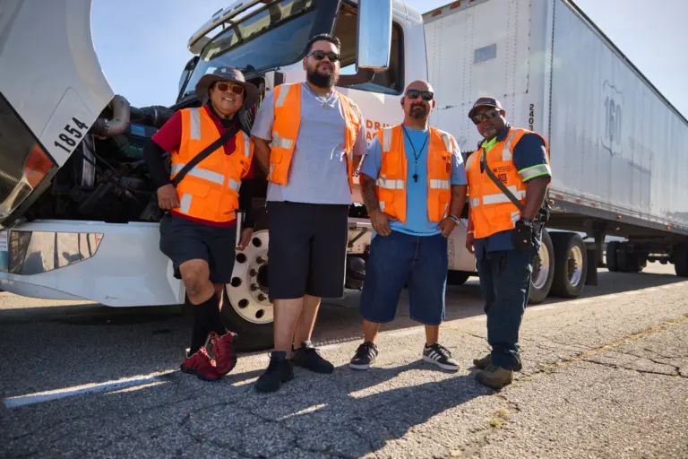 Four CDL students standing beside a truck