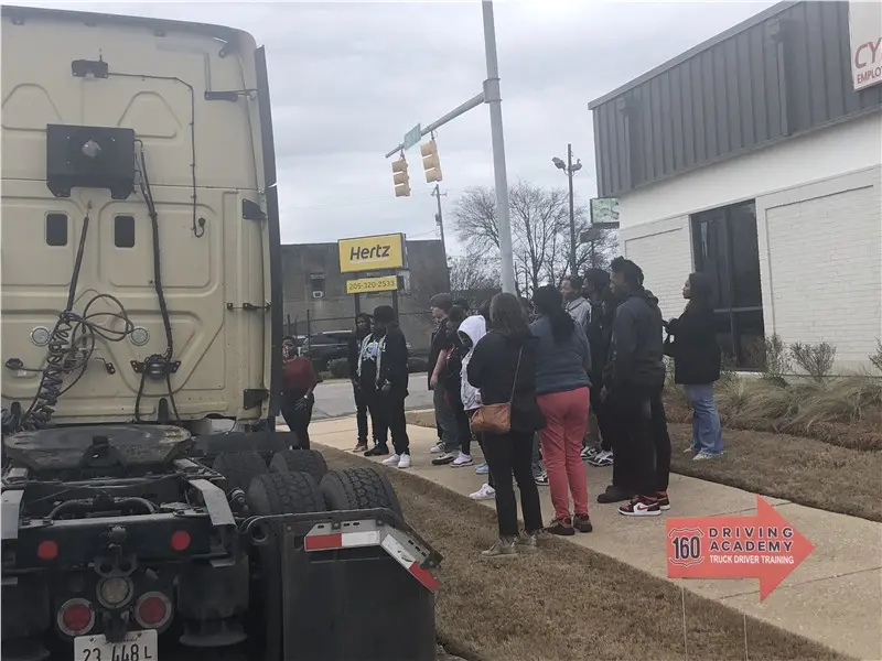Group of people observing a truck display outside