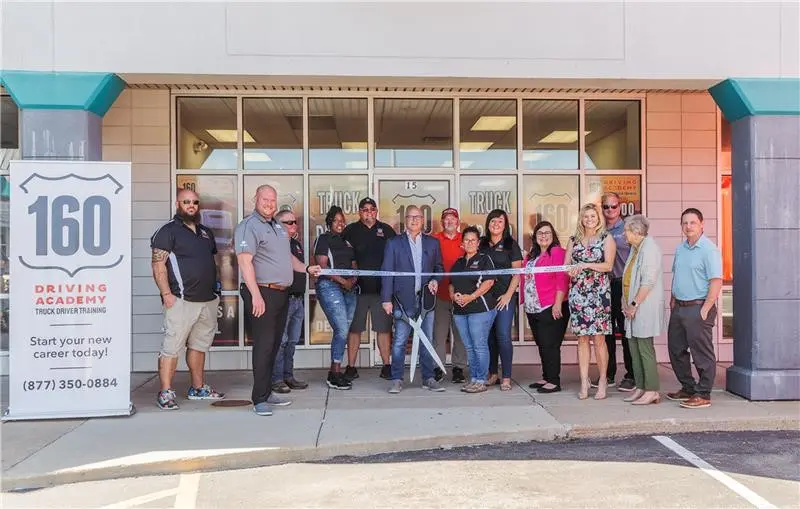 Group celebrating in front of 160 Driving Academy building