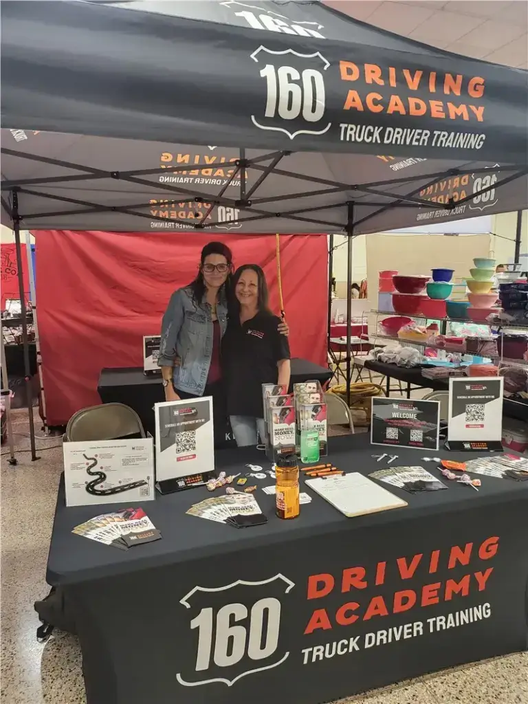 160 Driving Academy booth with smiling representatives