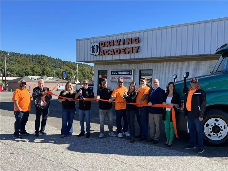 Group cutting ribbon outside 160 Driving Academy