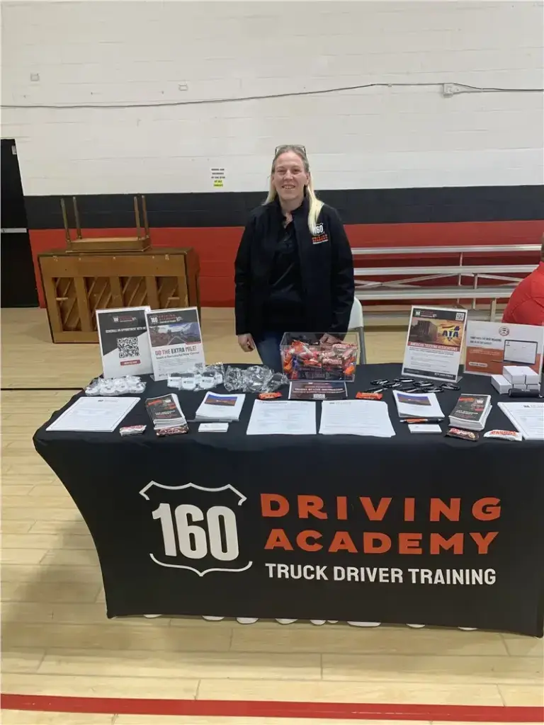 160 Driving Academy booth with representative smiling