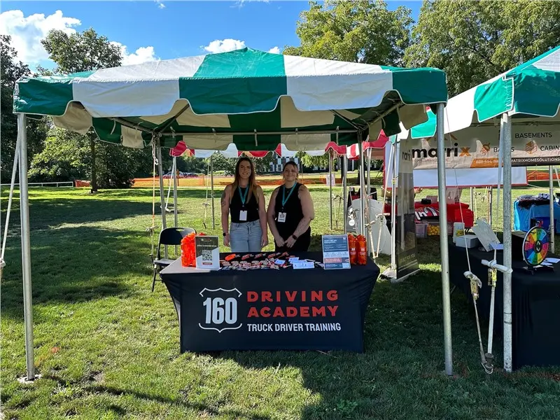 160 Driving Academy event booth with two representatives