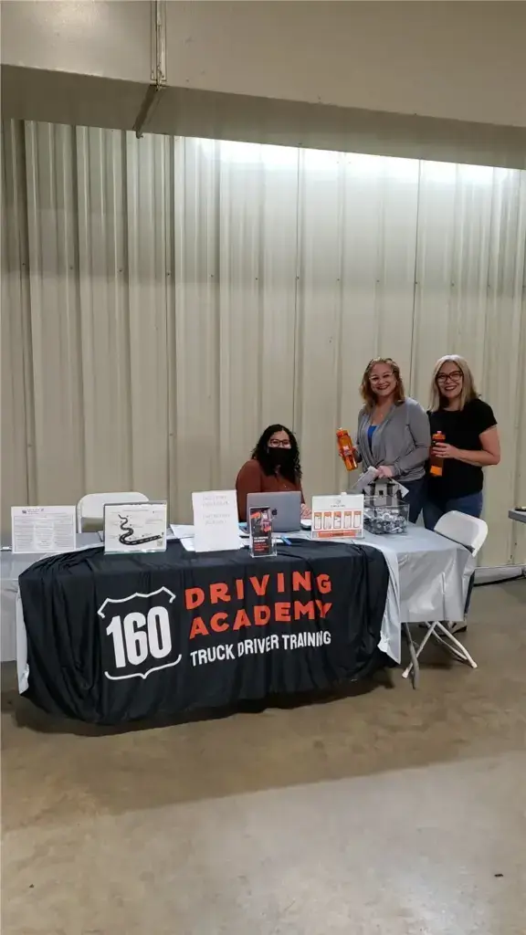 Three people at Driving Academy event booth