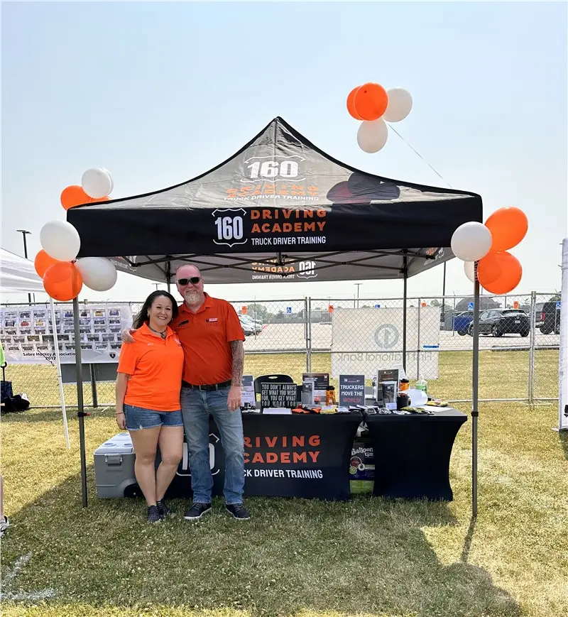 Driving academy booth at outdoor event with balloons