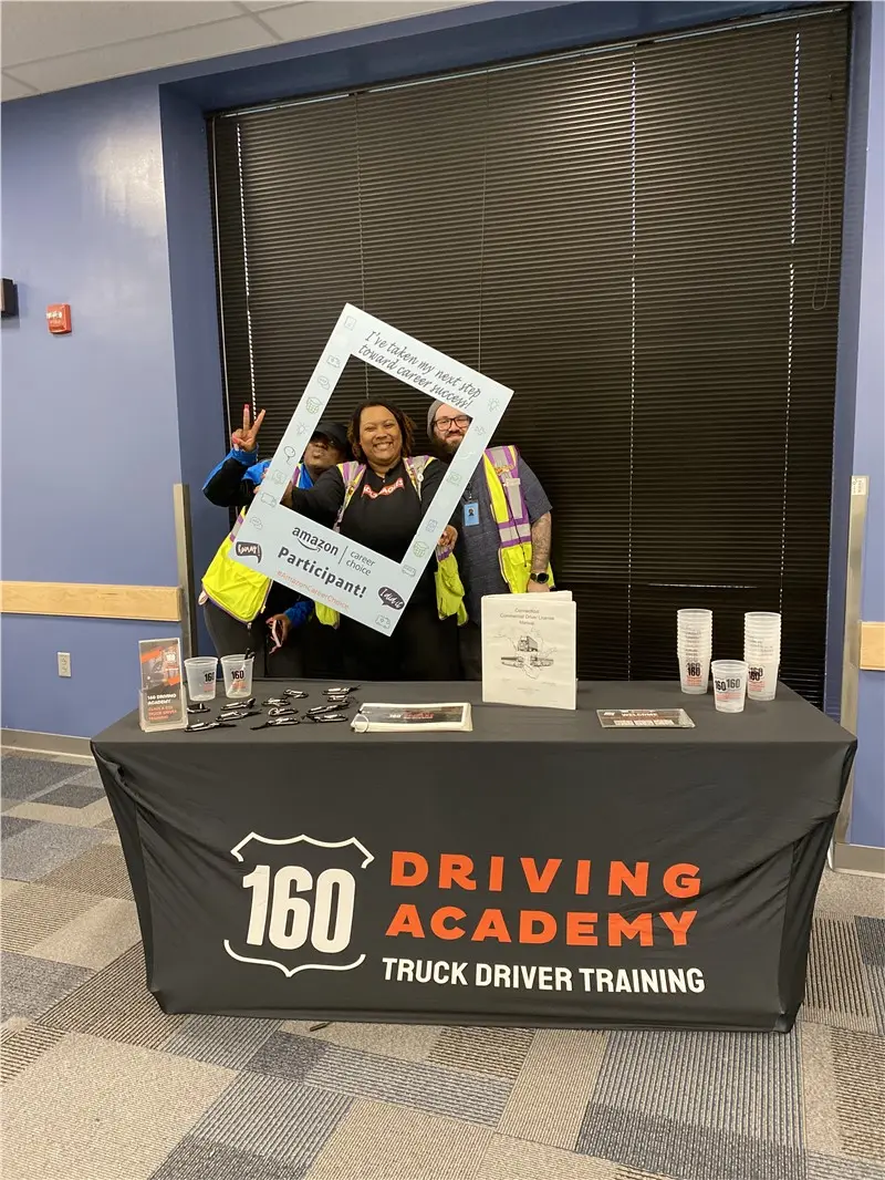 People posing with picture frame at event table