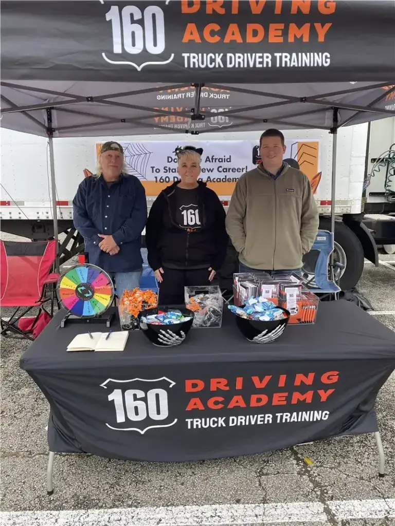 People at 160 Driving Academy event booth