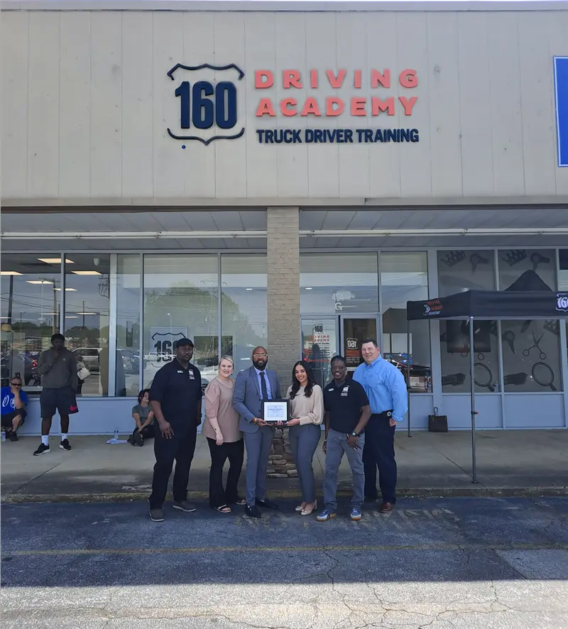 Group holding certificate outside 160 Driving Academy