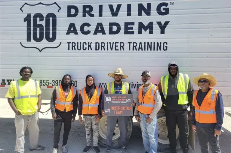 Instructors posing in front of truck