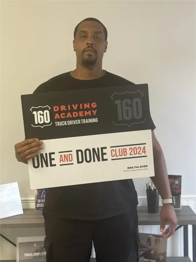 Man holding 160 Driving Academy promotional sign