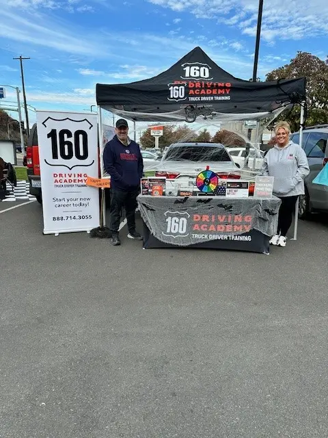 160 Driving Academy promotional booth with two representatives