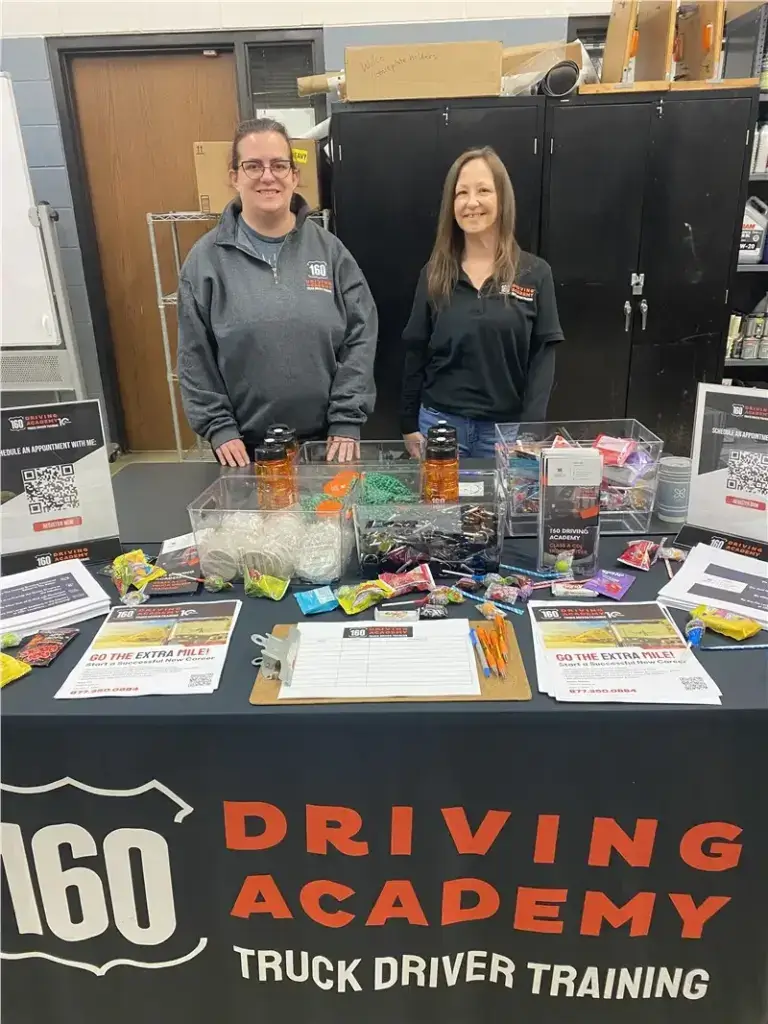 Two women at informational booth smiling