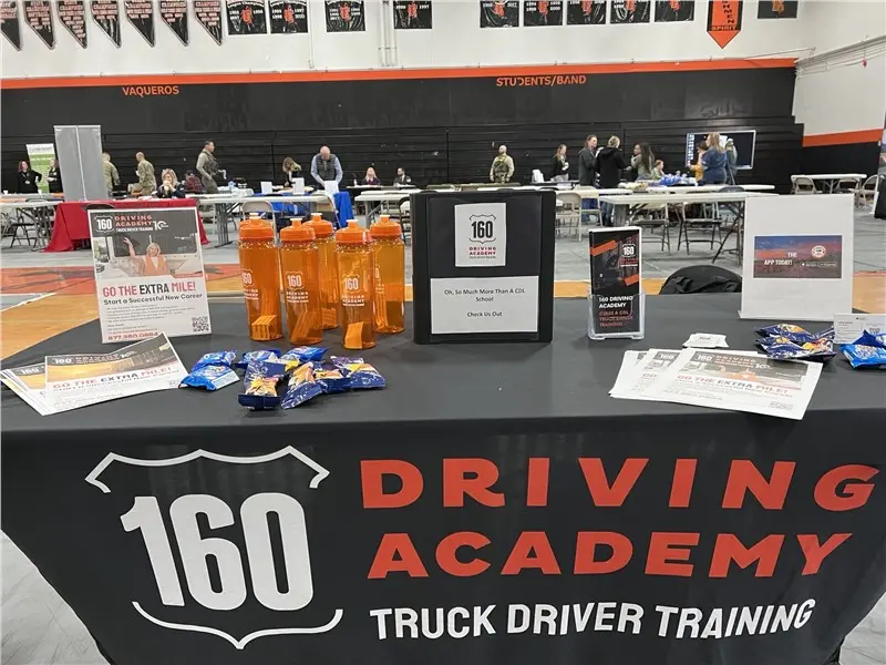 160 Driving Academy booth with promotional items displayed