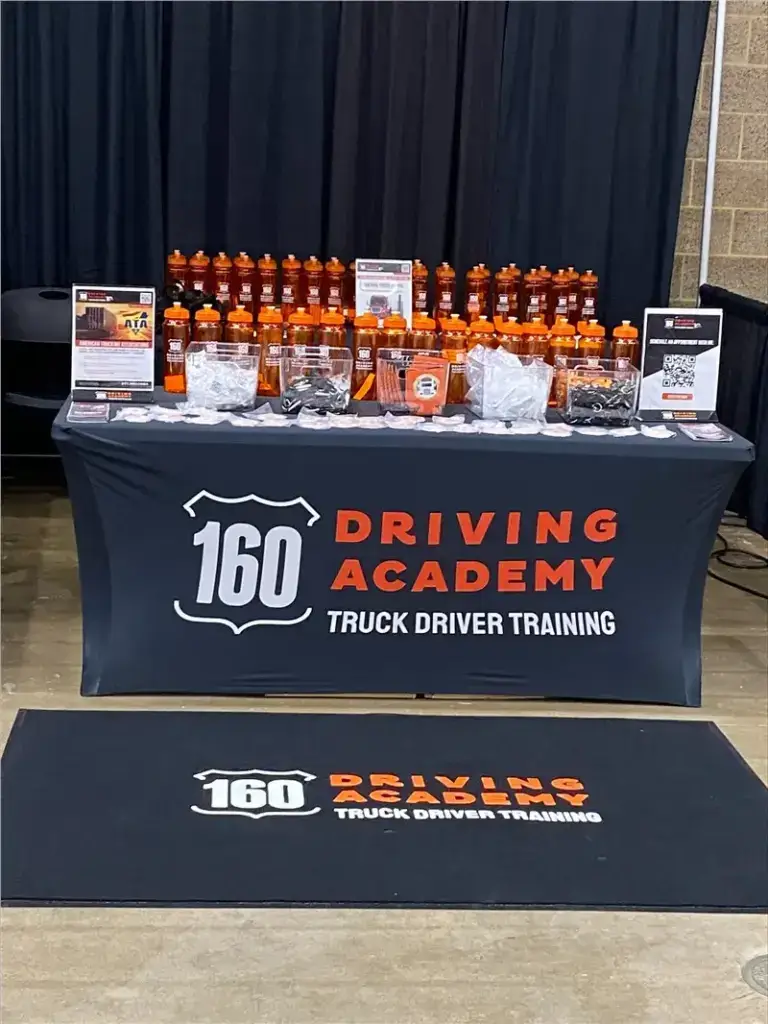 160 Driving Academy promotional booth with water bottles