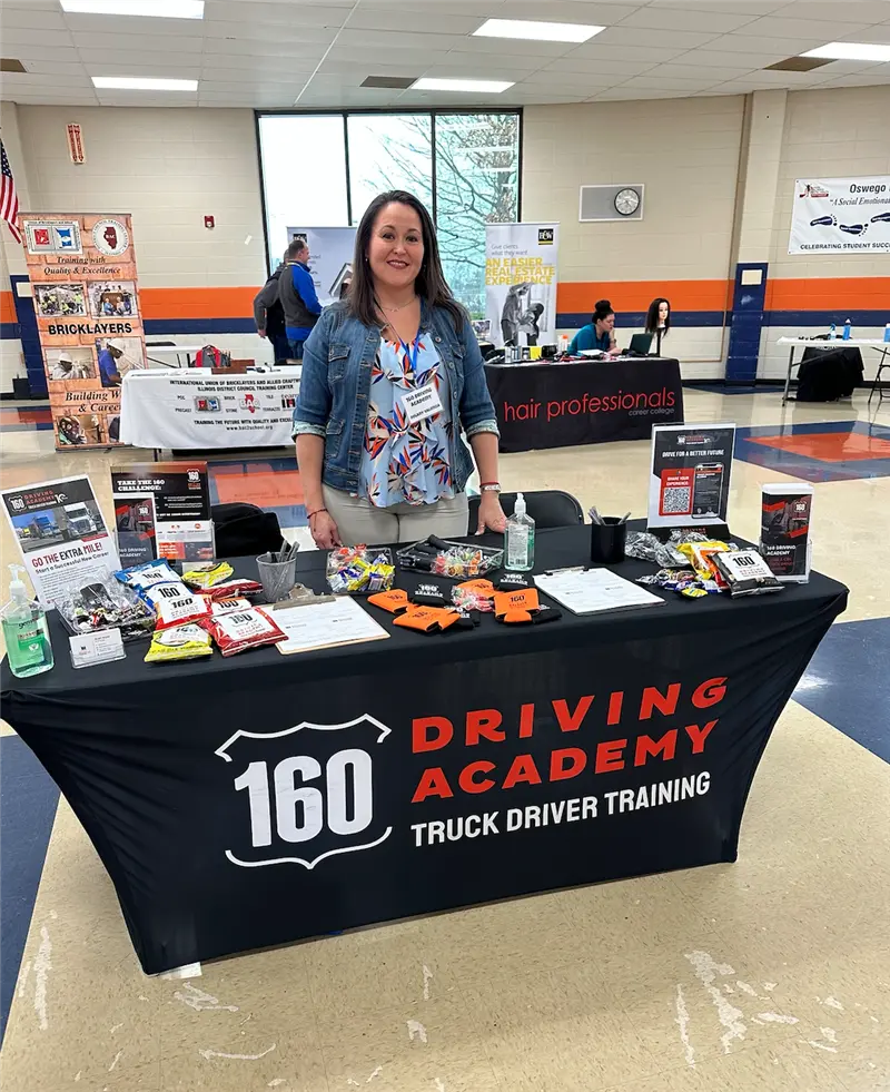 Woman standing behind recruitment table at career fair