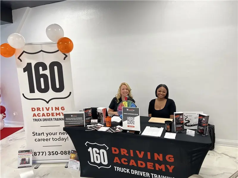 Two women at 160 Driving Academy recruitment table