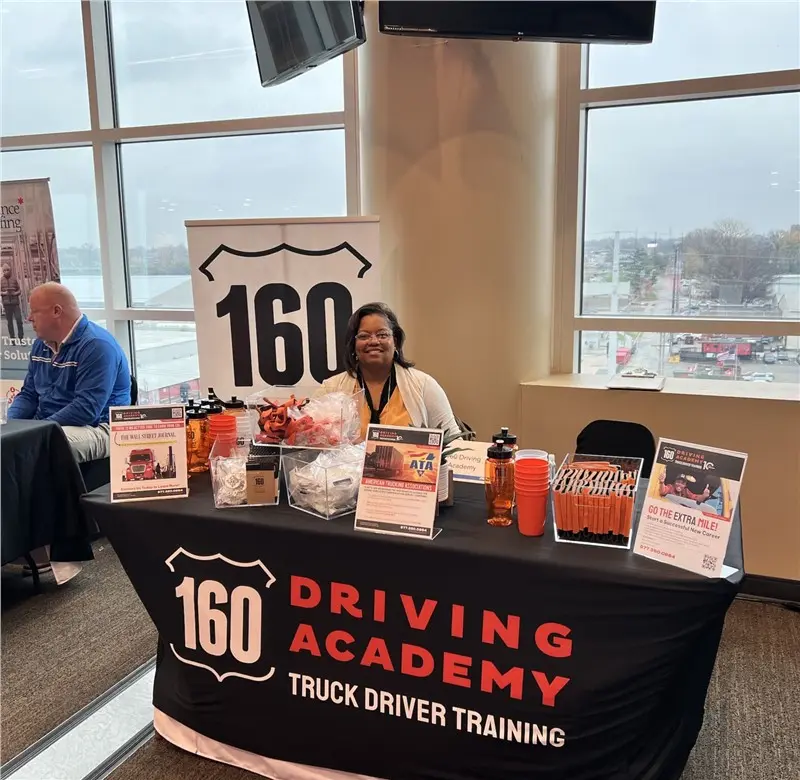 Woman at 160 Driving Academy trade show booth