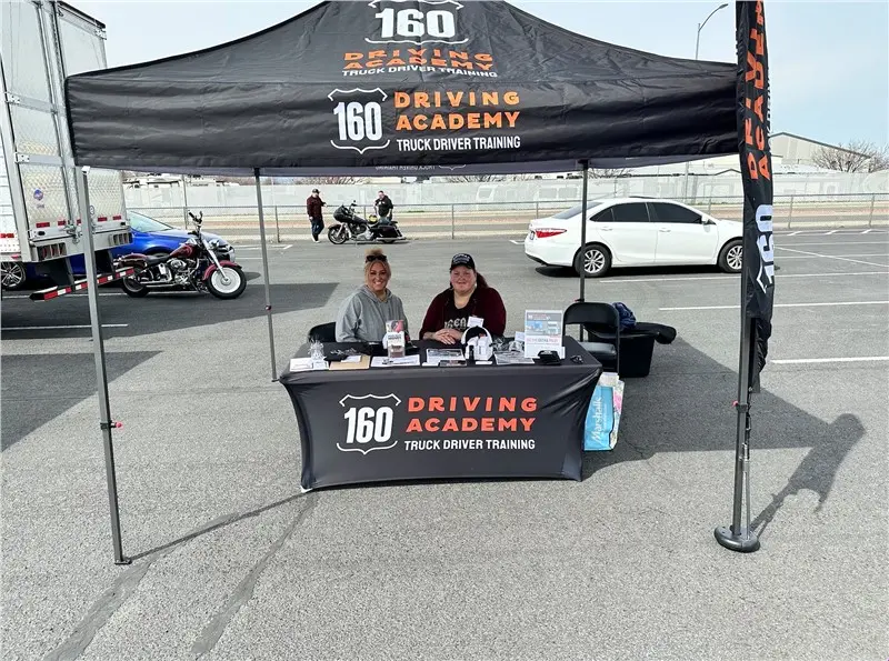 Driving Academy booth with two people seated outside