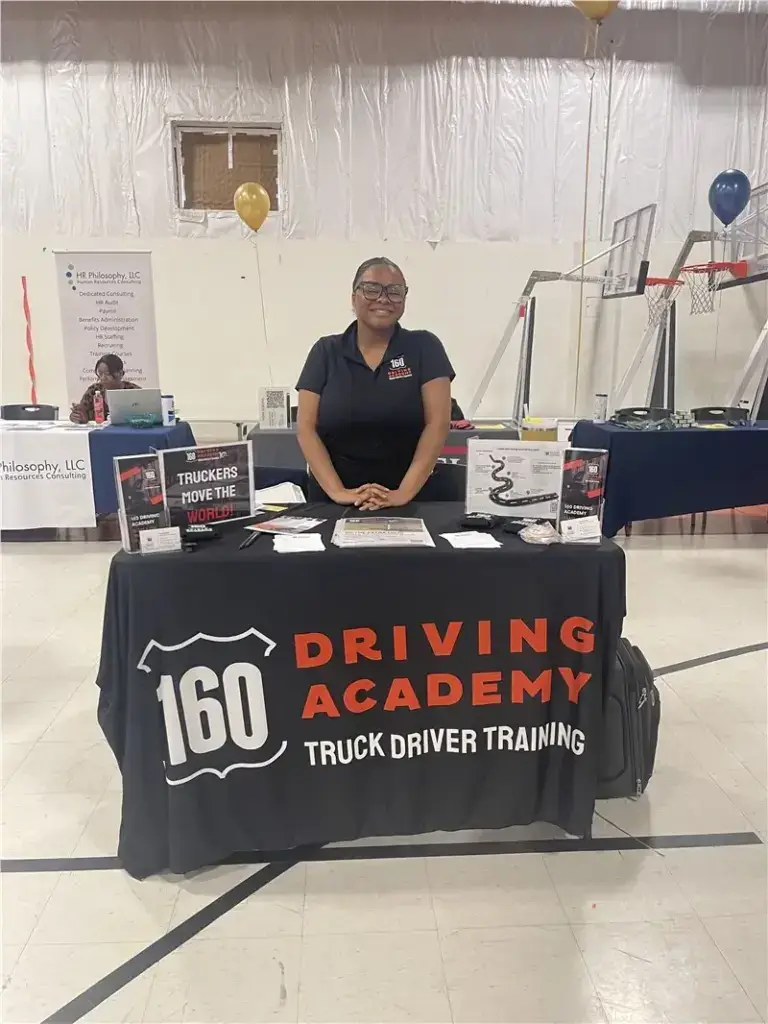 Smiling woman at 160 Driving Academy booth