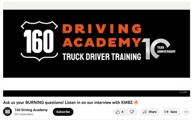 Woman holding sign beside academy truck