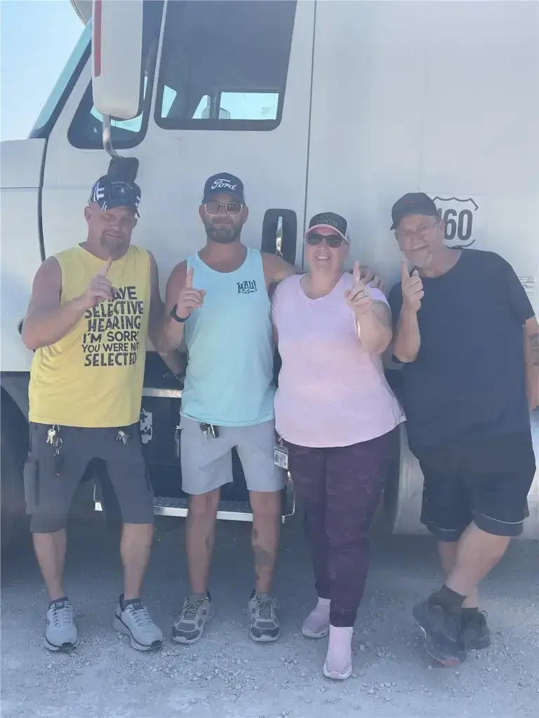 Graduated students standing together in front of truck