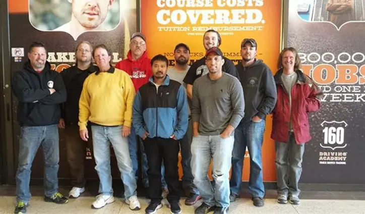 Group of men standing in front of academy display