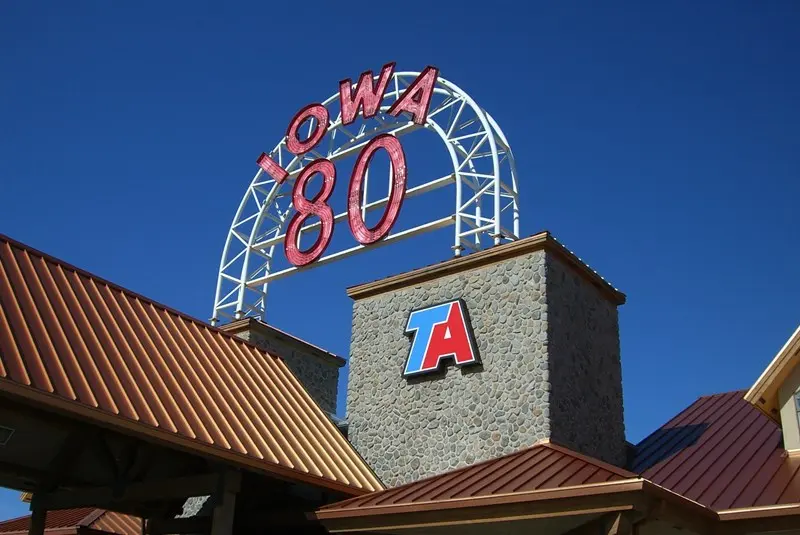 Iowa 80 Truck Stop entrance sign under blue sky