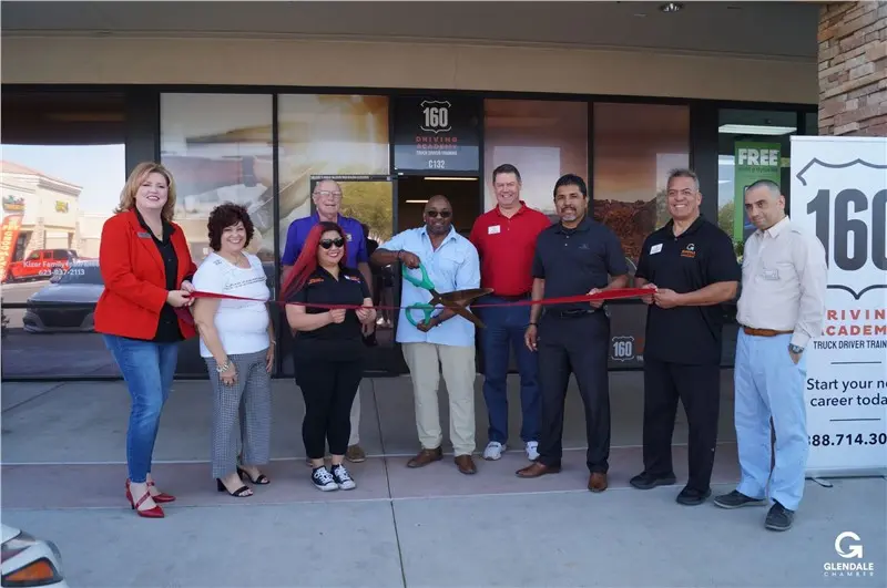 People celebrating ribbon cutting at 160 Driving Academy