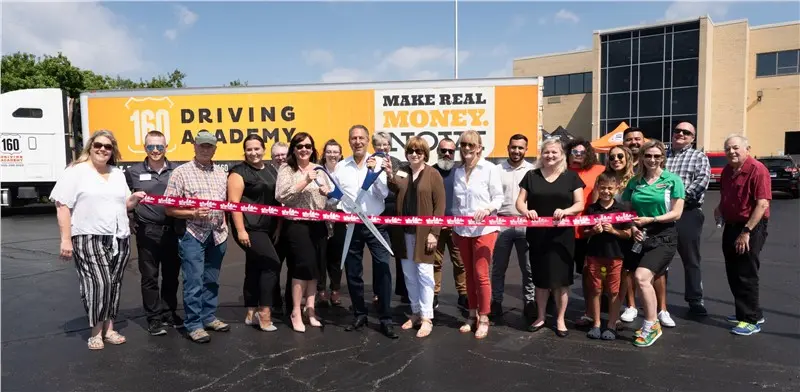 Group cutting ribbon at 160 Driving Academy ceremony