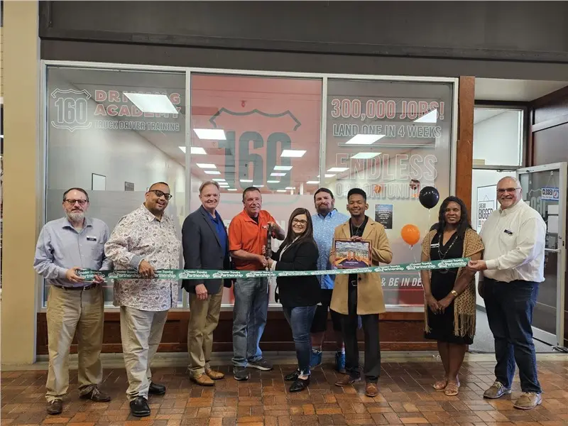 Group cutting ribbon at 160 Driving Academy
