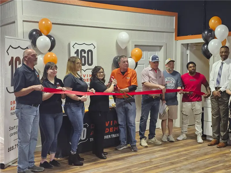 Group participating in ribbon cutting ceremony indoors