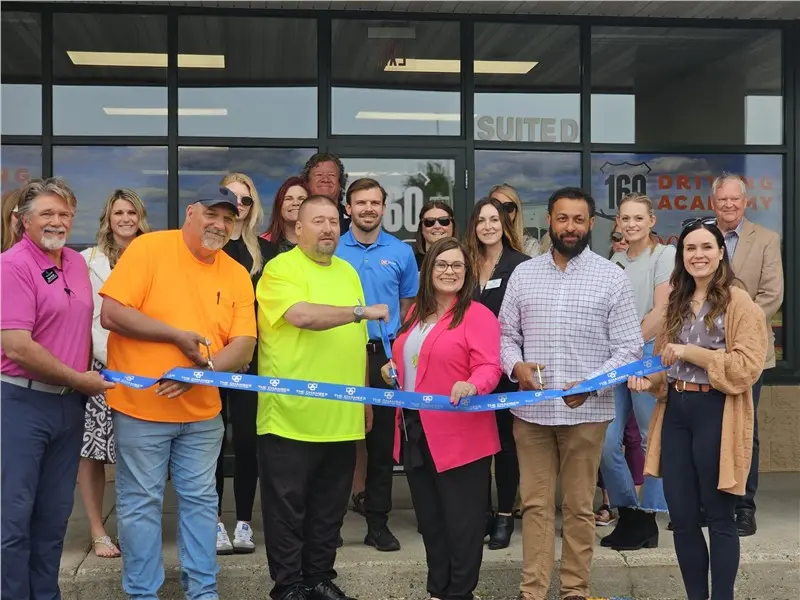 Group of people cutting ribbon at ceremony