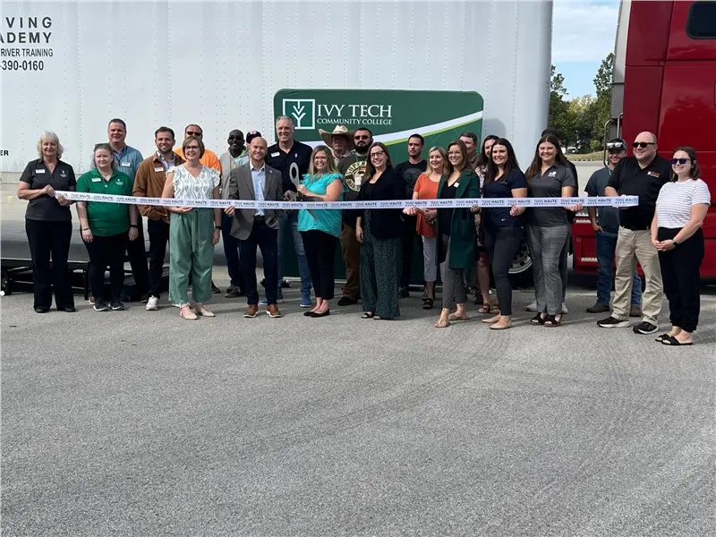 Group celebrating ribbon cutting ceremony outdoors