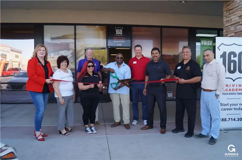 Group performing ribbon cutting at 160 Driving Academy