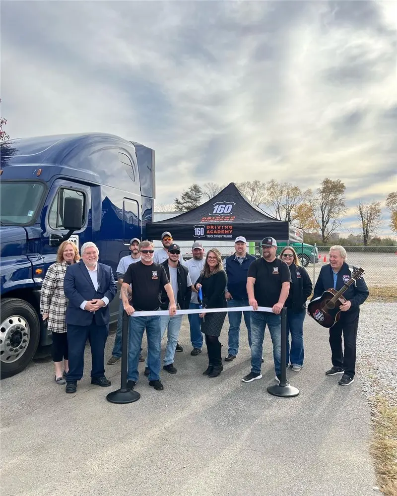 Group of people at truck driving ribbon-cutting event