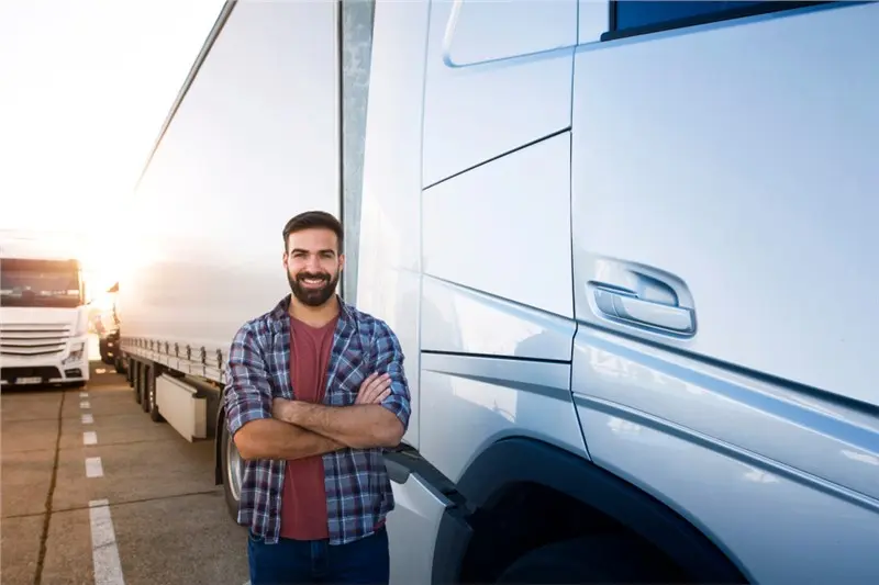 smiling man beside truck