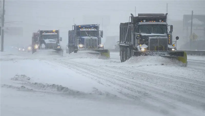 snow plows in winter storm