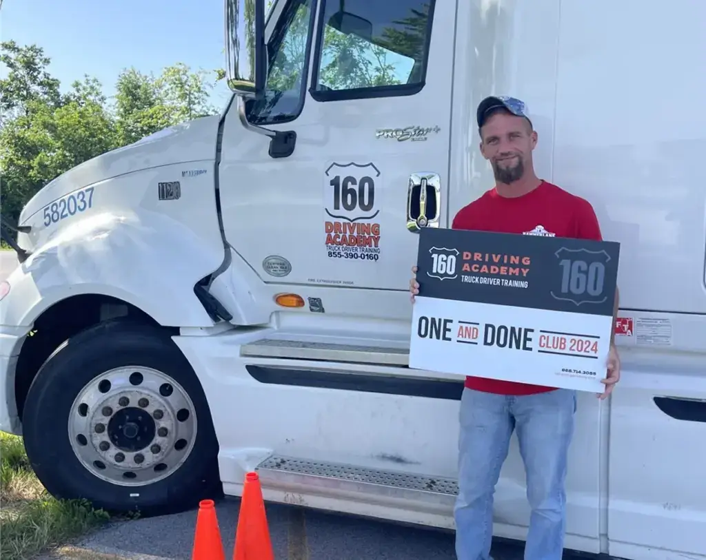 Man holding sign beside truck driver training vehicle