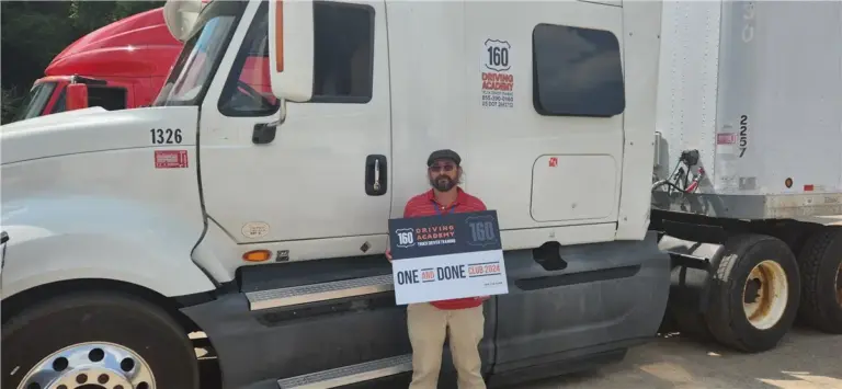 Graduate holding certificate beside truck