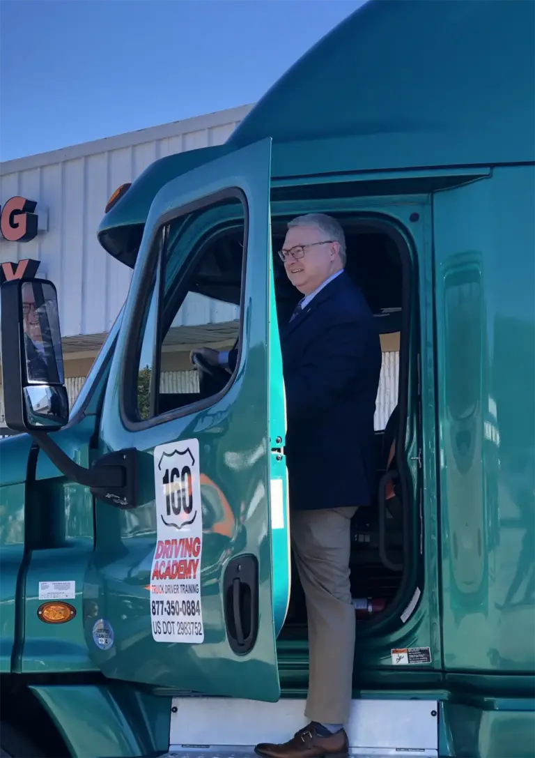 Man standing in truck doorway smiling