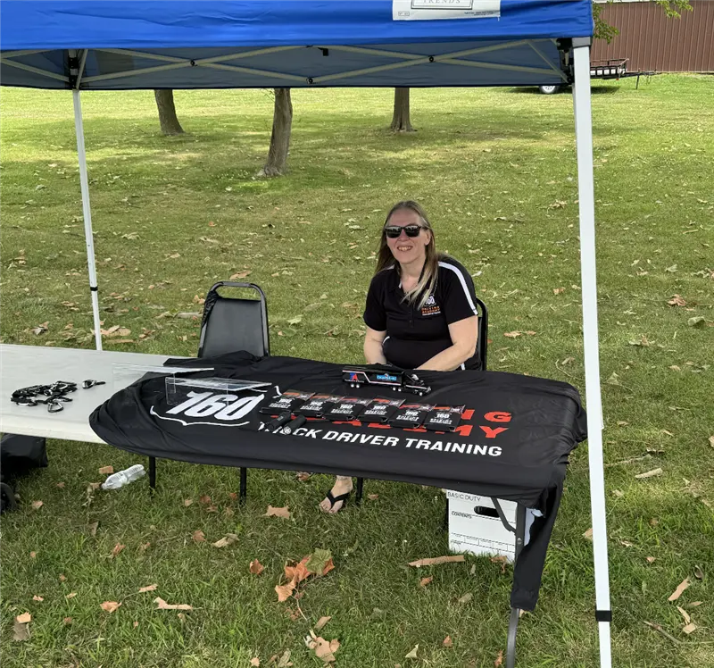 160 Driving Academy booth with seated staff member
