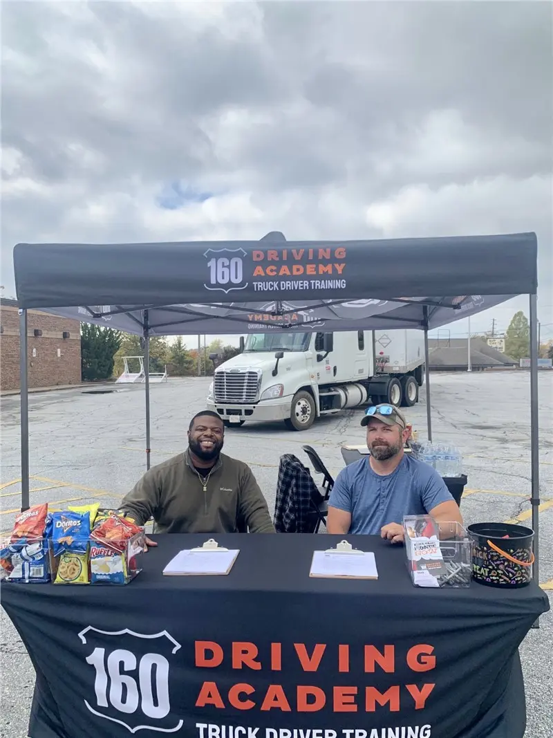 Truck driver training booth with two staff seated