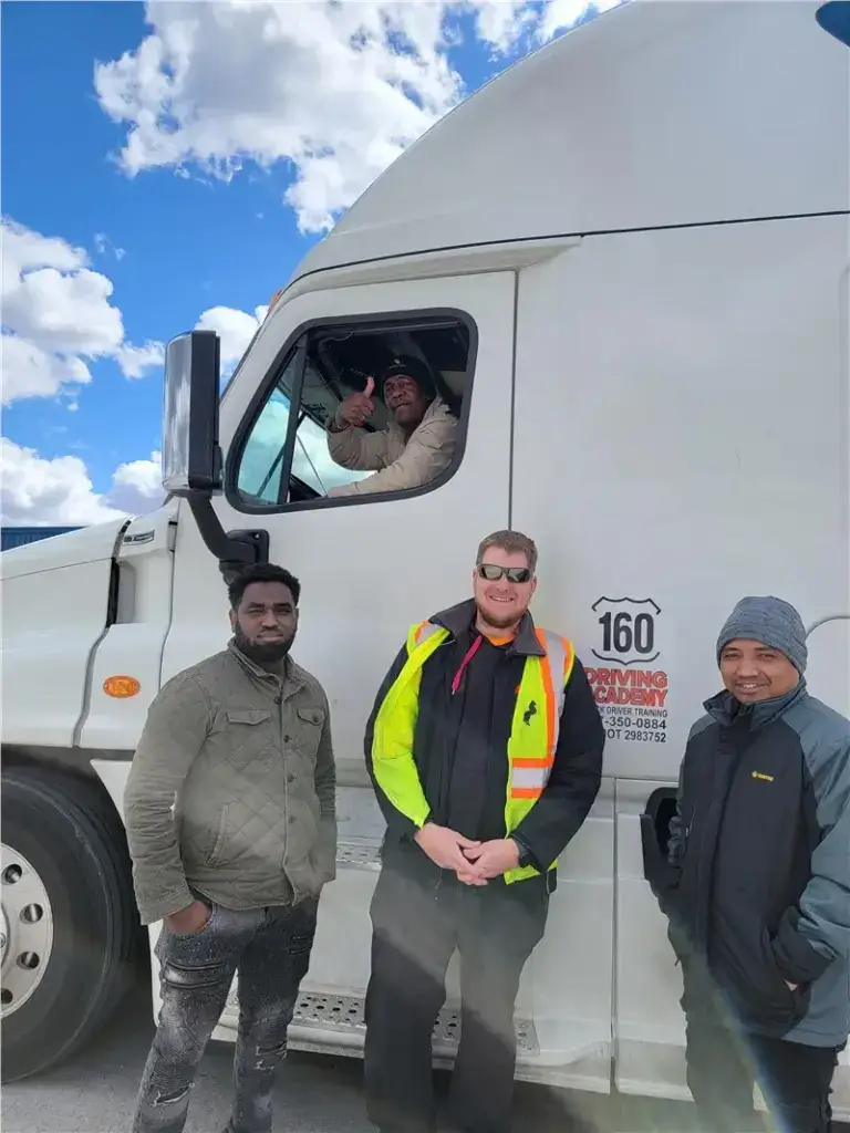 Truck drivers smiling beside large white truck